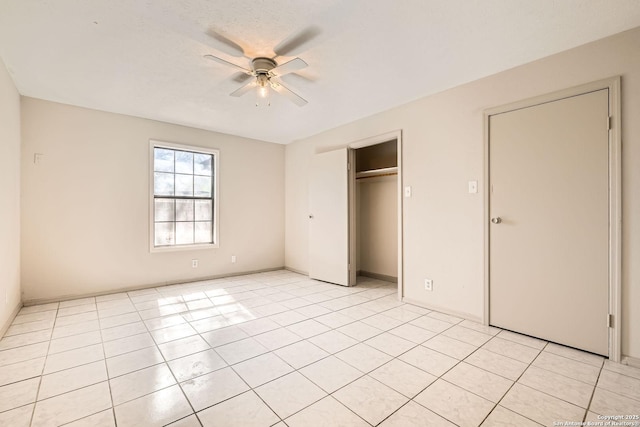 unfurnished bedroom featuring a closet, light tile patterned floors, and a ceiling fan