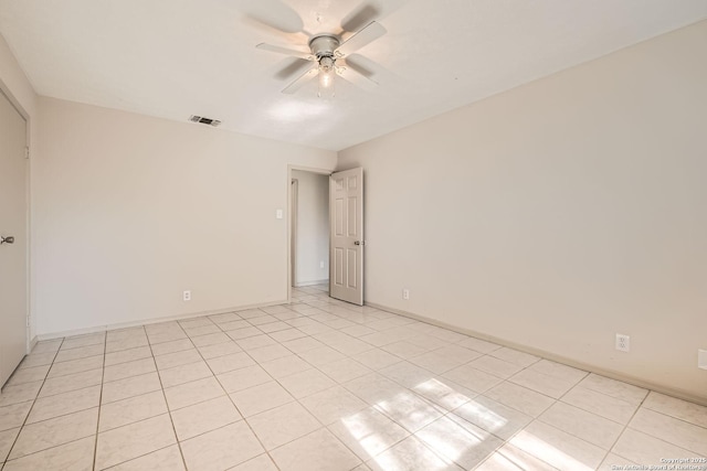 spare room featuring light tile patterned floors, baseboards, visible vents, and ceiling fan