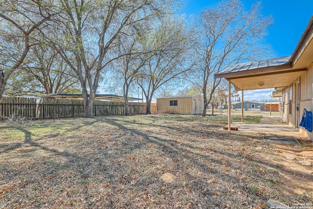 view of yard featuring an outbuilding, a storage shed, and fence