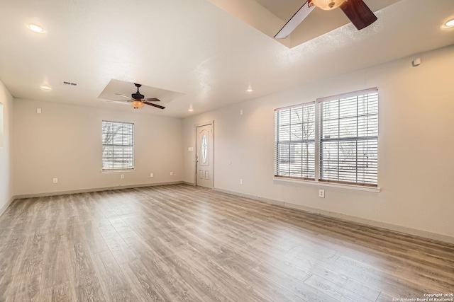 empty room with visible vents, light wood-style flooring, and a ceiling fan