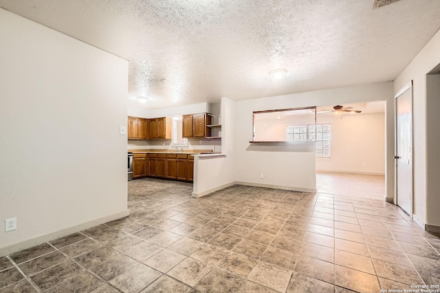 kitchen with a ceiling fan, baseboards, open shelves, light countertops, and brown cabinets