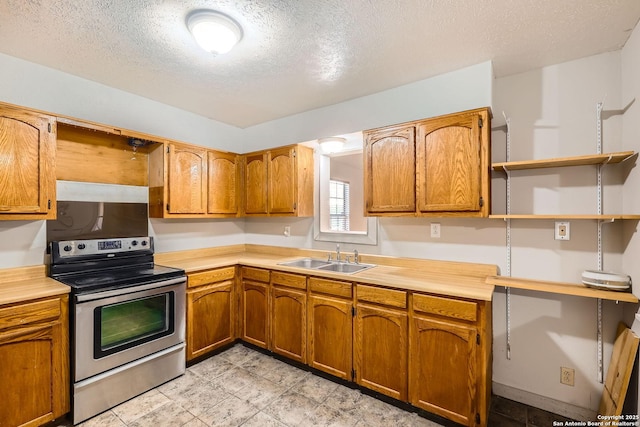 kitchen featuring a sink, brown cabinetry, light countertops, and electric stove