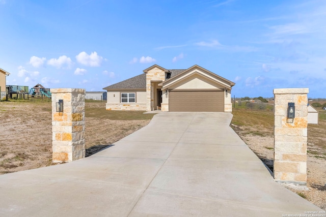 view of front facade with a garage, stone siding, roof with shingles, and driveway