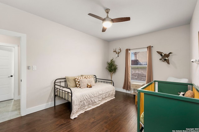 bedroom featuring baseboards, dark wood-type flooring, and a ceiling fan