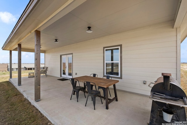 view of patio featuring outdoor dining space, a grill, and french doors