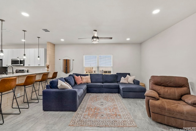 living area featuring light wood finished floors, visible vents, recessed lighting, and a ceiling fan