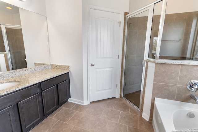 bathroom with tile patterned floors, a stall shower, vanity, and a garden tub