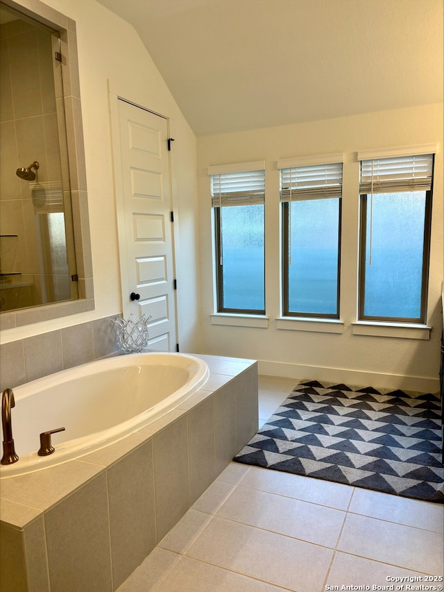 bathroom featuring tiled shower, a garden tub, lofted ceiling, and tile patterned flooring