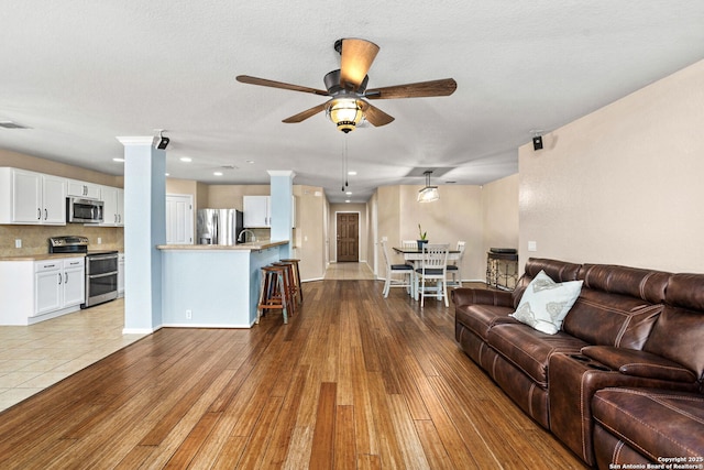 living area with recessed lighting, baseboards, ceiling fan, and hardwood / wood-style floors