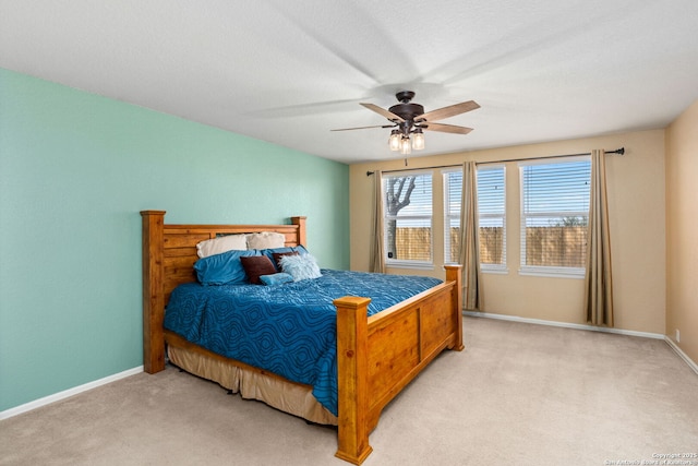 bedroom featuring a ceiling fan, baseboards, and light carpet