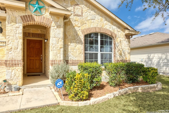 doorway to property featuring stone siding and brick siding