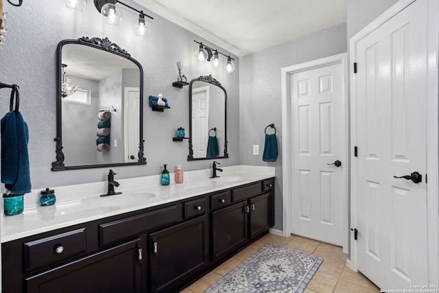 bathroom featuring a sink, a notable chandelier, double vanity, and tile patterned flooring