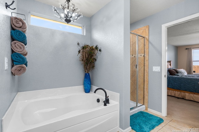 ensuite bathroom featuring a bath, a notable chandelier, a stall shower, and ensuite bathroom