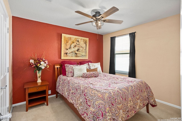 carpeted bedroom with baseboards and a ceiling fan