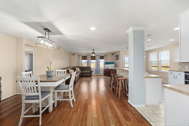 dining room featuring wood finished floors, a wealth of natural light, and ceiling fan