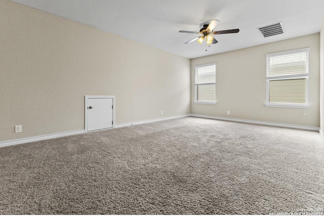 spare room with baseboards, visible vents, a ceiling fan, and carpet