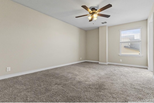 carpeted spare room with a ceiling fan, visible vents, and baseboards