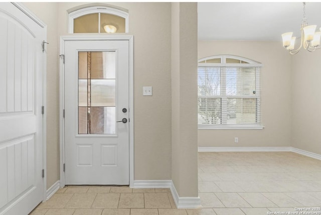 foyer with light tile patterned floors, baseboards, and a chandelier