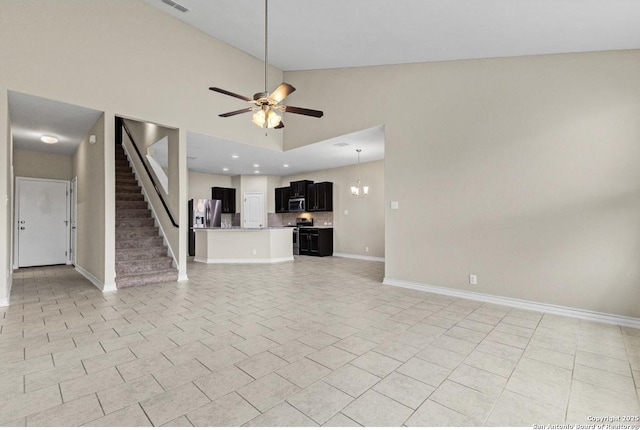 unfurnished living room with stairway, light tile patterned floors, a ceiling fan, and baseboards