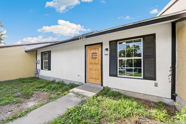 property entrance with stucco siding