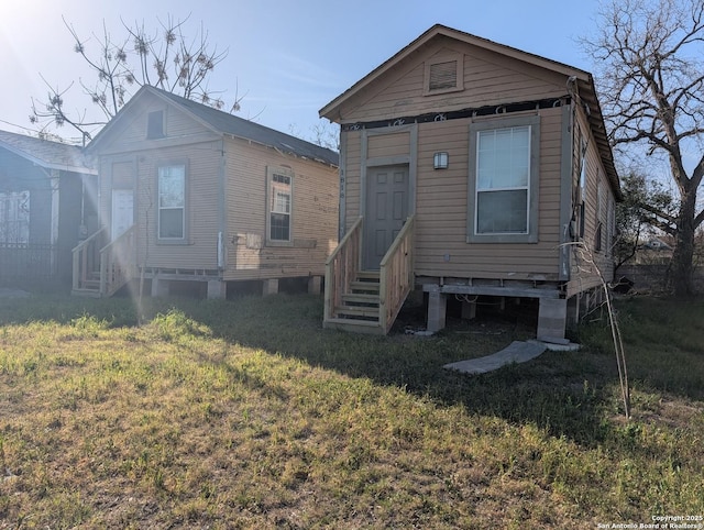 back of property with a yard and entry steps