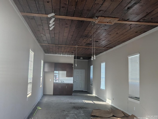 unfurnished living room with rail lighting, wood ceiling, and concrete flooring