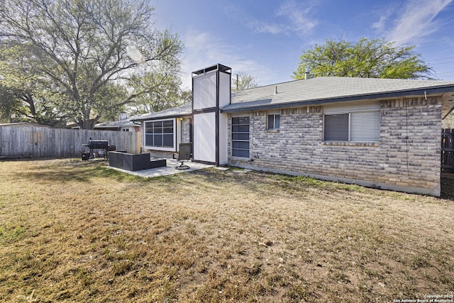 rear view of house with fence, a lawn, a chimney, outdoor lounge area, and a patio