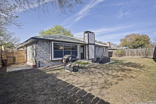 back of property featuring a lawn, a chimney, and fence