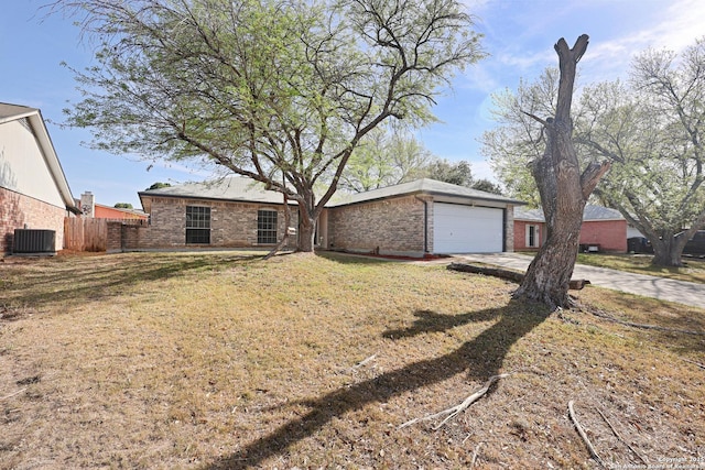 view of front of home featuring central air condition unit, fence, concrete driveway, an attached garage, and brick siding