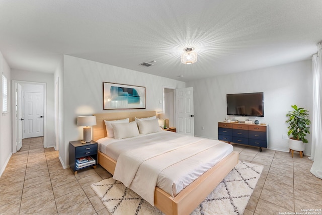 bedroom featuring light tile patterned floors, baseboards, and visible vents