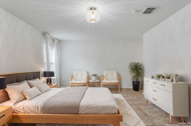 bedroom featuring light tile patterned floors and visible vents