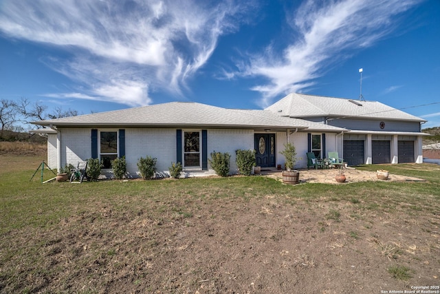 ranch-style house with a front yard, an attached garage, brick siding, and roof with shingles