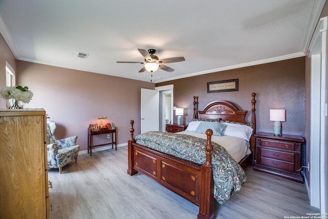 bedroom with visible vents, crown molding, baseboards, and wood finished floors