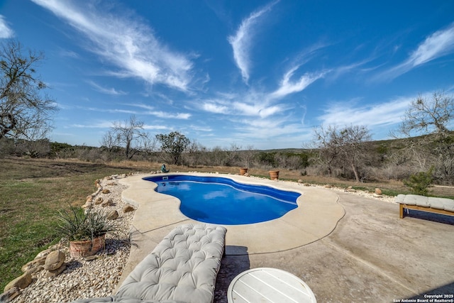 outdoor pool with a patio area