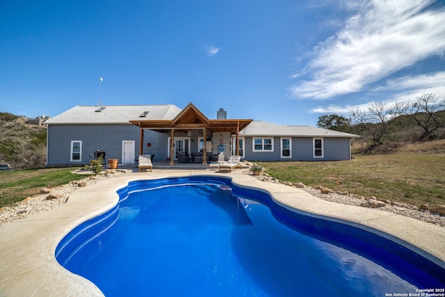 pool with a patio and a lawn