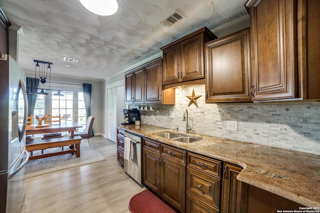 kitchen with a sink, visible vents, light stone countertops, and appliances with stainless steel finishes