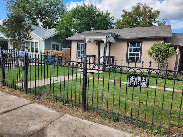 bungalow featuring a fenced front yard and a front lawn