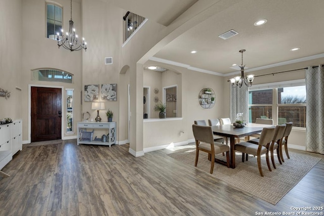 dining room with visible vents, wood finished floors, baseboards, and a chandelier