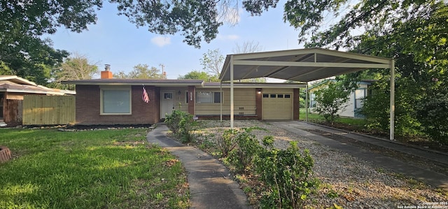 view of front facade featuring brick siding, fence, a chimney, driveway, and an attached garage