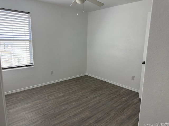 spare room with baseboards, dark wood-type flooring, and ceiling fan