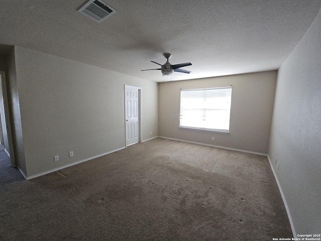 spare room with visible vents, a textured ceiling, baseboards, and carpet