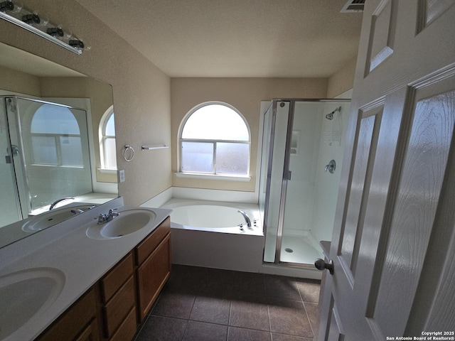 bathroom featuring a bath, tile patterned floors, a stall shower, and a sink