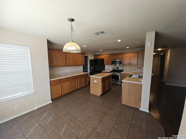 kitchen with a kitchen island, light countertops, brown cabinetry, stainless steel appliances, and a sink