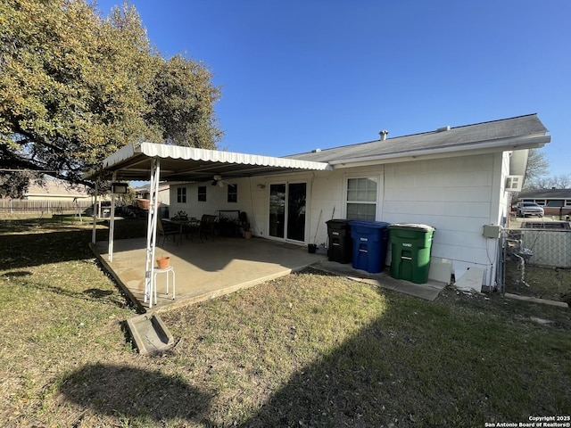 rear view of house with a patio area, roof with shingles, a yard, and fence