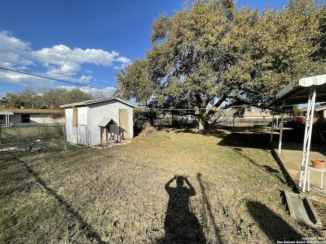 view of yard with a fenced backyard, a storage unit, and an outdoor structure