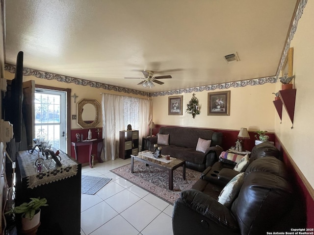 living area with light tile patterned floors, a ceiling fan, and visible vents