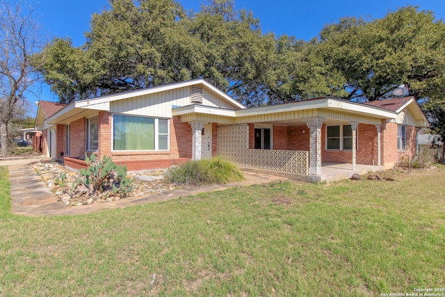 ranch-style home featuring brick siding and a front yard