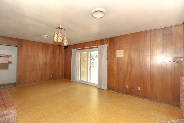 unfurnished room featuring wooden walls