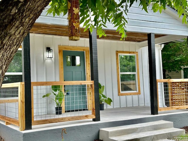 property entrance featuring covered porch and board and batten siding