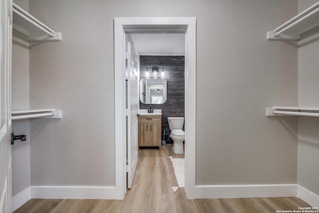 spacious closet with light wood-type flooring and a sink